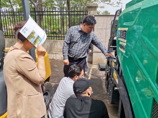 开云足球徐工道路机械负责人李彬为客户介绍徐工摊铺机